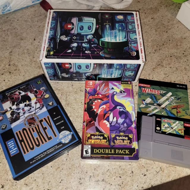Awesome Nes GGRetroBox with the games Pokemon Scarlet and Violet Double Pack (Nintendo Switch), Wings (NES), and NHL Hockey (Sega Gensis)