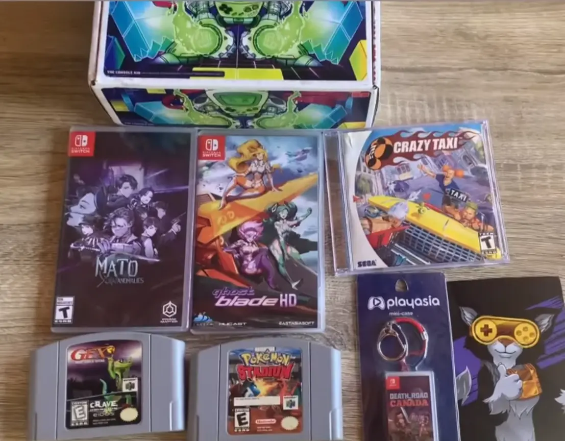 Console Kid GGRetroBox with the games Mato Anamolies (Switch), ghost blade HD (Switch), Crazy Taxi (Dreamcast), Pokemon Stadium (N64), and Gex (N64)